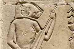 175_Egypte_Philae_Temple-d-Hathor-construit-par-Ptolemee-VI_Relief_Baboin-jouant-d-un-Instrument-a-Cordes