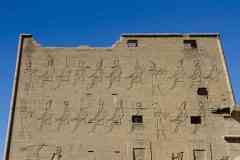 227_Egypte_Edfou_Temple-d-Horus_Le-Pylone_Relief_Ptolemee-XII-devant-les-Dieux-portant-les-Diverses-Coiffes-d-Egypte
